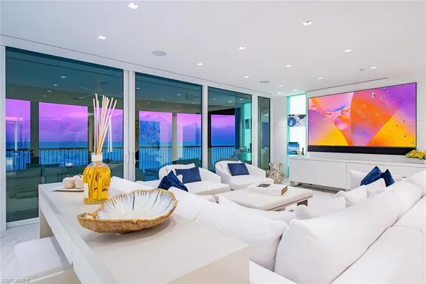 a living room with furniture kitchen view and a large window