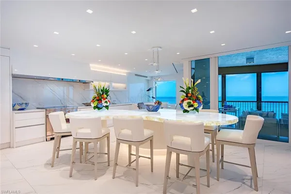 a dining hall with stainless steel appliances a dining table and chairs