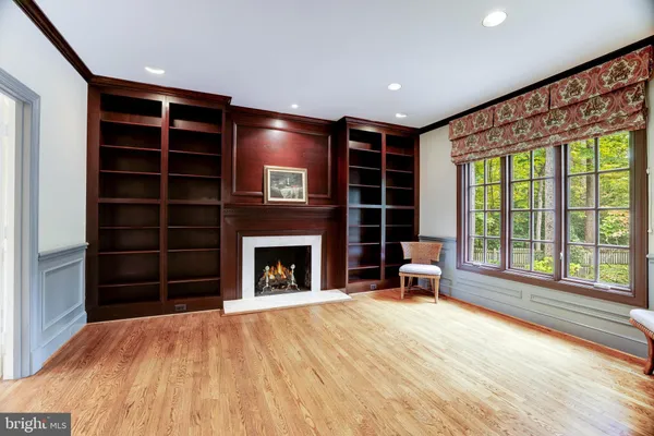 a view of empty room with wooden floor and fireplace