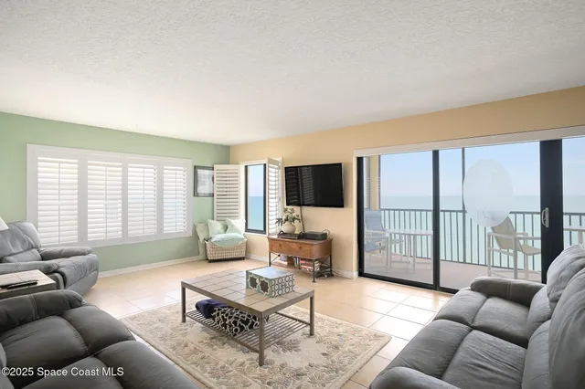 a living room with furniture a large window and a flat screen tv