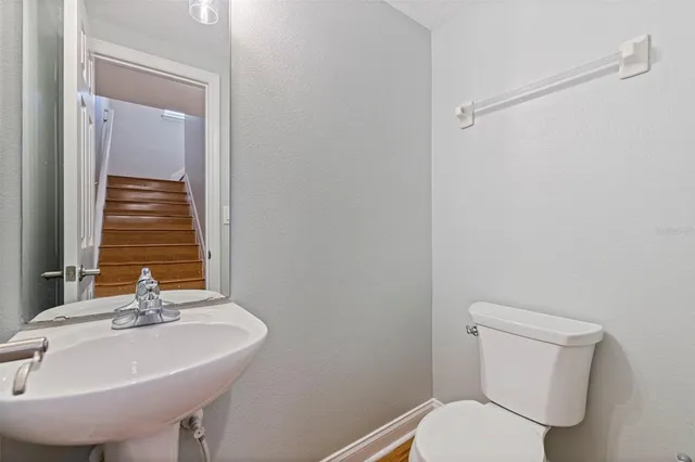 a bathroom with a sink a toilet and a mirror