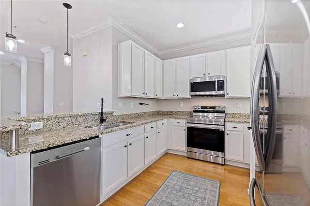 a kitchen with stainless steel appliances granite countertop a sink stove and refrigerator