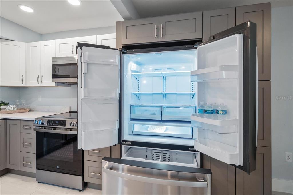 1 Windrush Boulevard, Unit 45 Indian Rocks Beach, FL 33785 - Photo 13 of 53 a stove top oven sitting inside of a kitchen