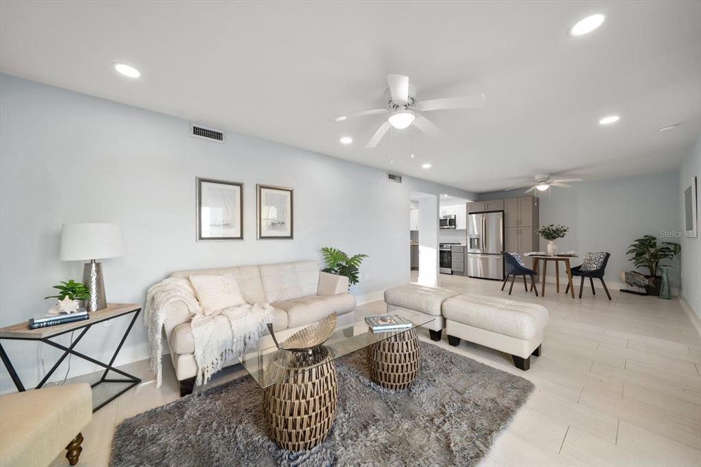 1 Windrush Boulevard, Unit 45 Indian Rocks Beach, FL 33785 - Photo 9 of 53 a living room with furniture and a chandelier