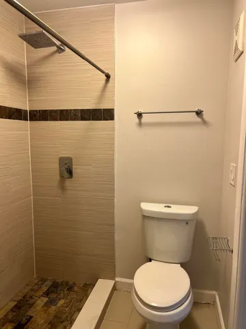 a bathroom with a toilet and a shower