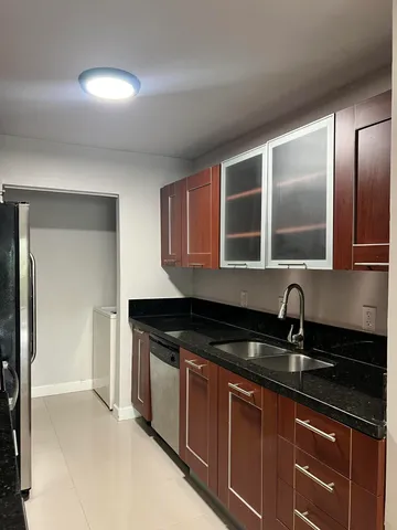 a kitchen with granite countertop a sink and cabinets