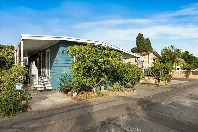 a yellow house with a trees in front of it