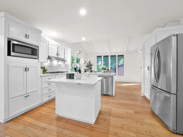a kitchen with white cabinets and white appliances