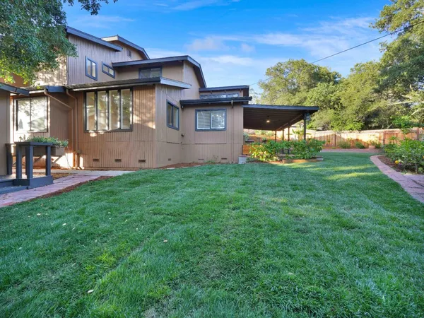 a view of backyard with outdoor seating and green space