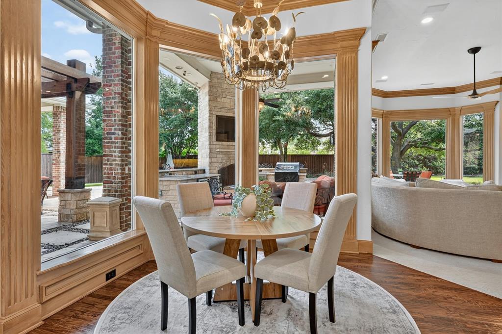 6416 Riverside Drive Plano, TX 75024 - Photo 12 of 35 Wood-finish flooring with a circular area rug, surrounded by extensive bay windows featuring light wood trim and fluted columns