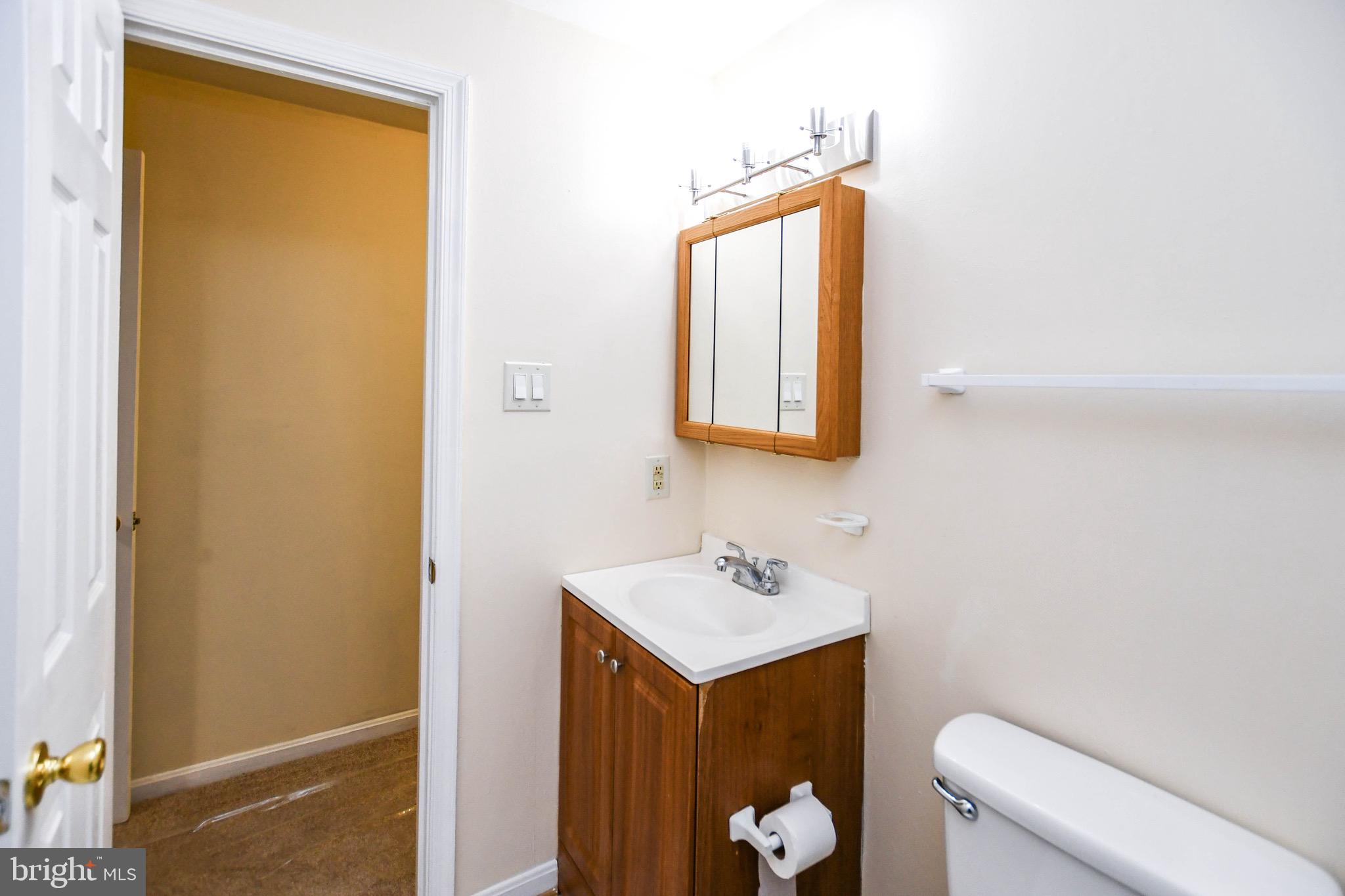 12411 Sturdee Drive Upper Marlboro, MD 20772 - Photo 17 of 39 a bathroom with a toilet sink and mirror