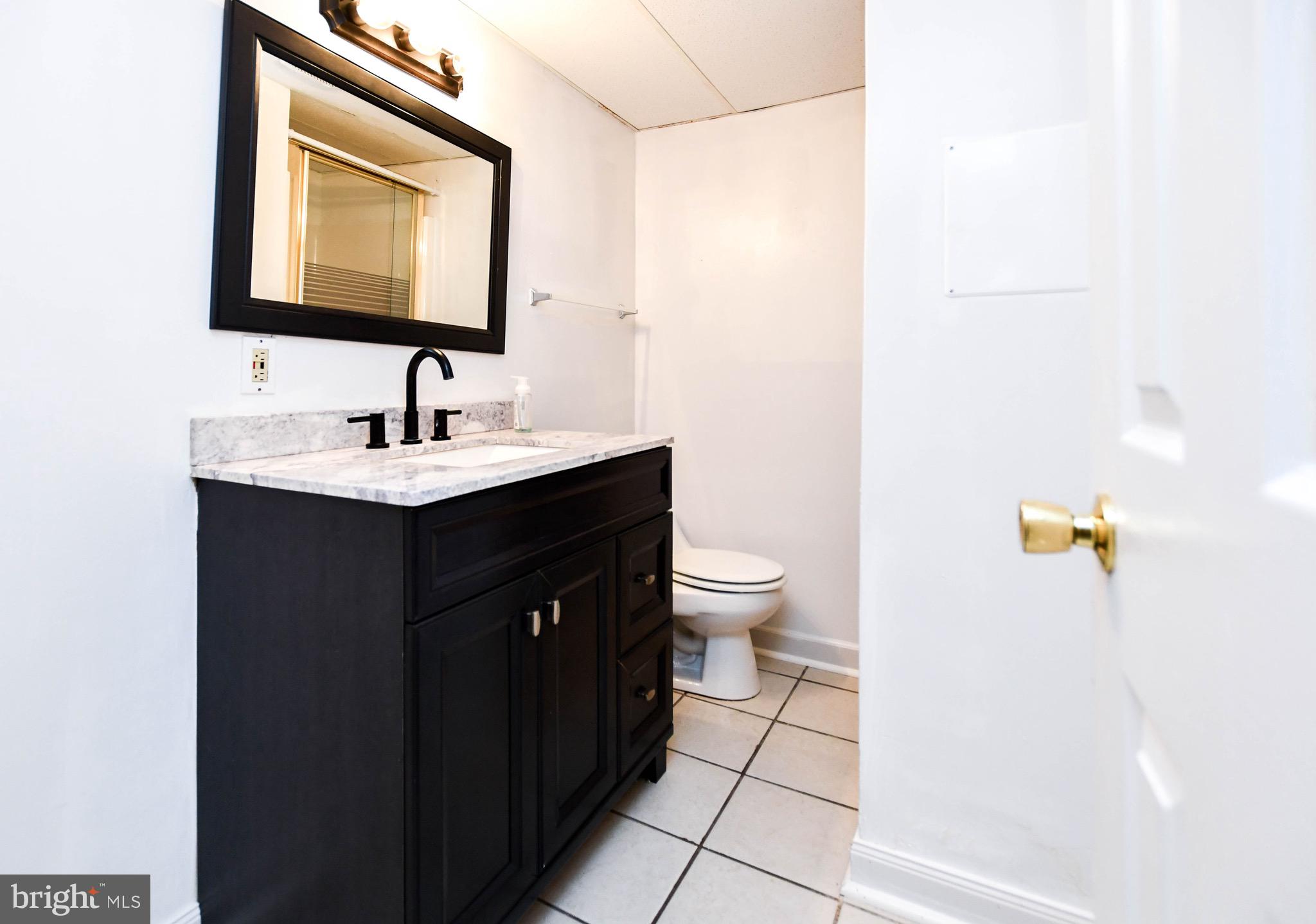 12411 Sturdee Drive Upper Marlboro, MD 20772 - Photo 29 of 39 a bathroom with a toilet sink and mirror