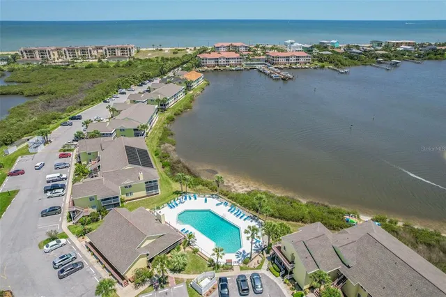 an aerial view of residential houses with outdoor space and swimming pool