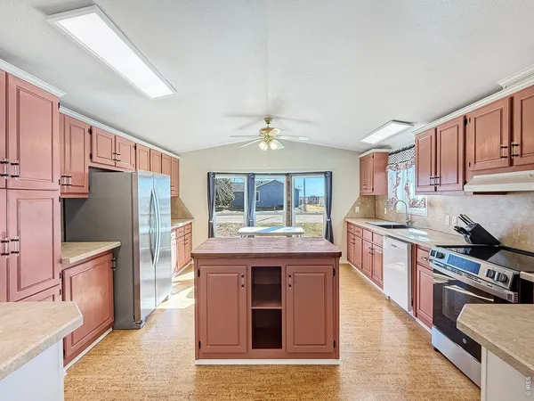 a kitchen with stainless steel appliances granite countertop a stove refrigerator and cabinets