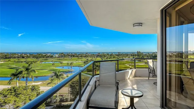 a view of a balcony with dining table & chairs