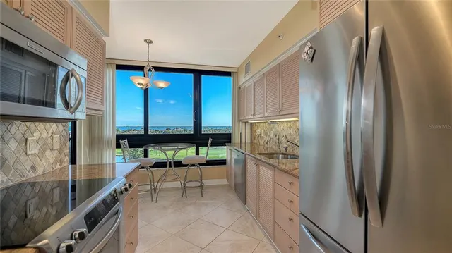 a kitchen with stainless steel appliances granite countertop a refrigerator and a stove