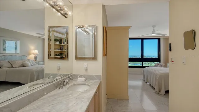 a en suite bathroom with a granite countertop sink and a mirror