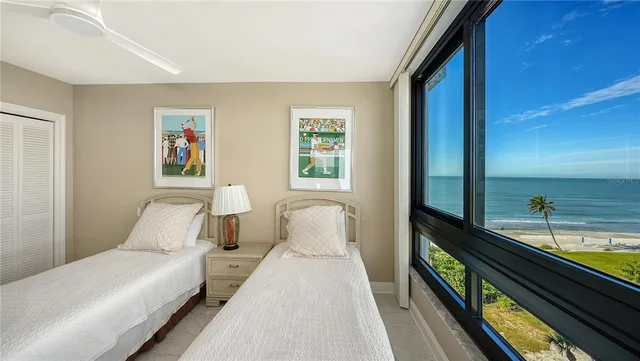a bedroom with a bed and a large window with balcony view