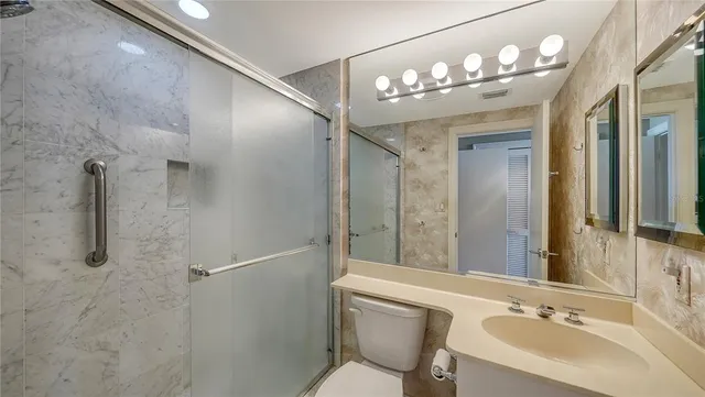 a bathroom with a sink vanity mirror and toilet