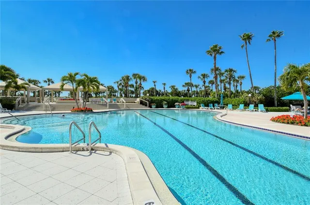 a view of a swimming pool with a yard and sitting area