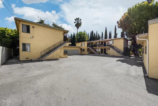 a view of a house with backyard and a tree
