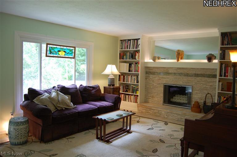12060 Clark Road Chardon, OH 44024 - Photo 2 of 21 Living Room with stacked stone hearth, custom built bookshelves and easy care tile flooring.