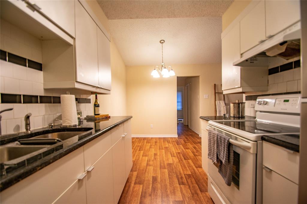 1817 Lipscomb Street Fort Worth, TX 76110 - Photo 5 of 10 Kitchen with light hardwood / wood-style flooring, white cabinetry, backsplash, a notable chandelier, and white range with electric stovetop