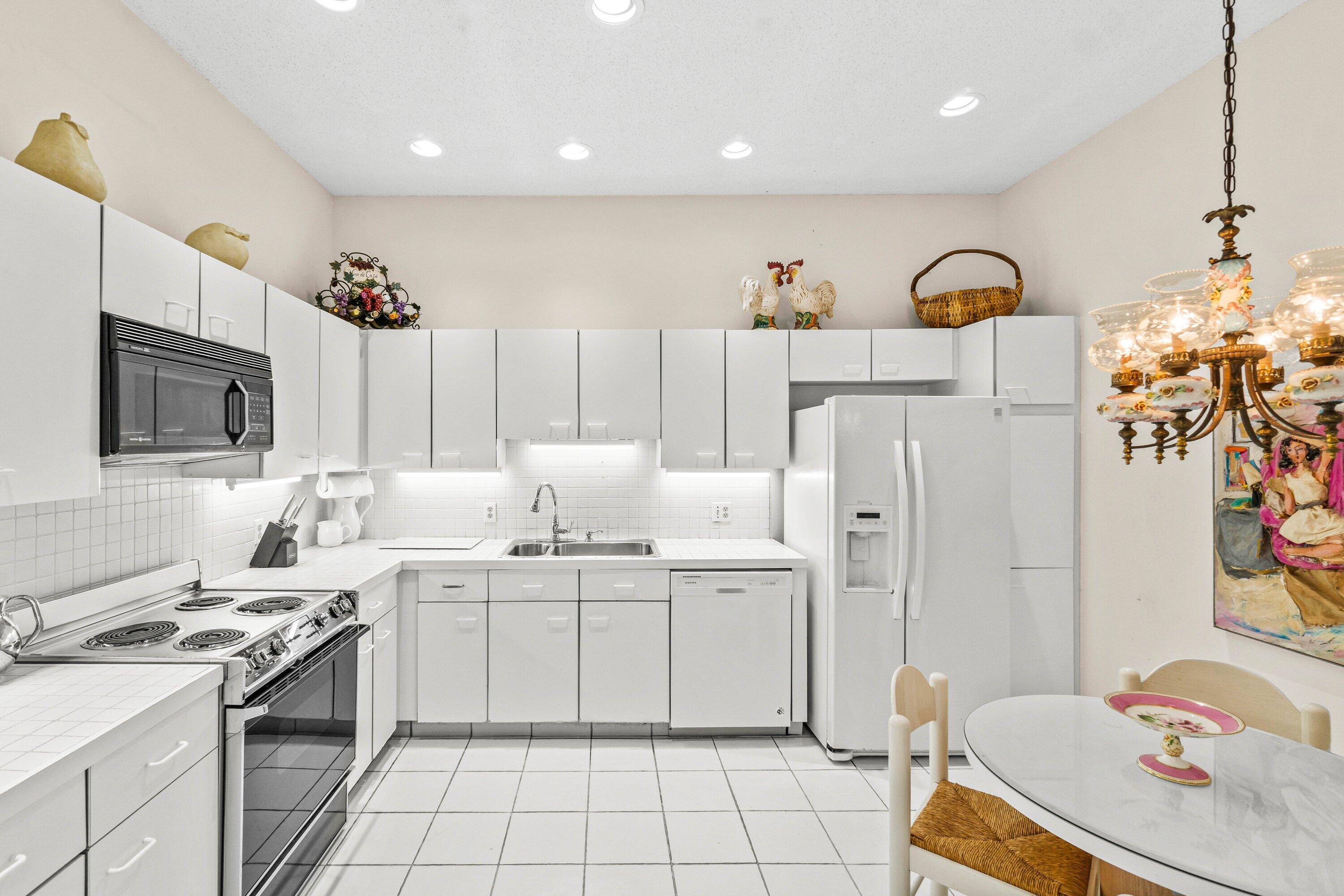 5184 Lake Catalina Drive, Unit D Boca Raton, FL 33496 - Photo 2 of 54 a kitchen with stainless steel appliances kitchen island granite countertop a sink and cabinets