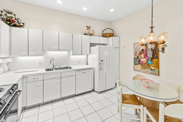 a kitchen with stainless steel appliances kitchen island granite countertop a sink a stove a dining table and chairs
