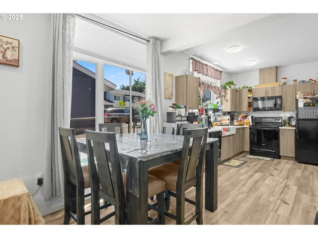 a open kitchen with stainless steel appliances granite countertop a refrigerator a sink dishwasher stove and oven with wooden cabinets