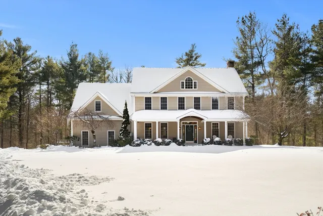a front view of a house with a yard covered with snow