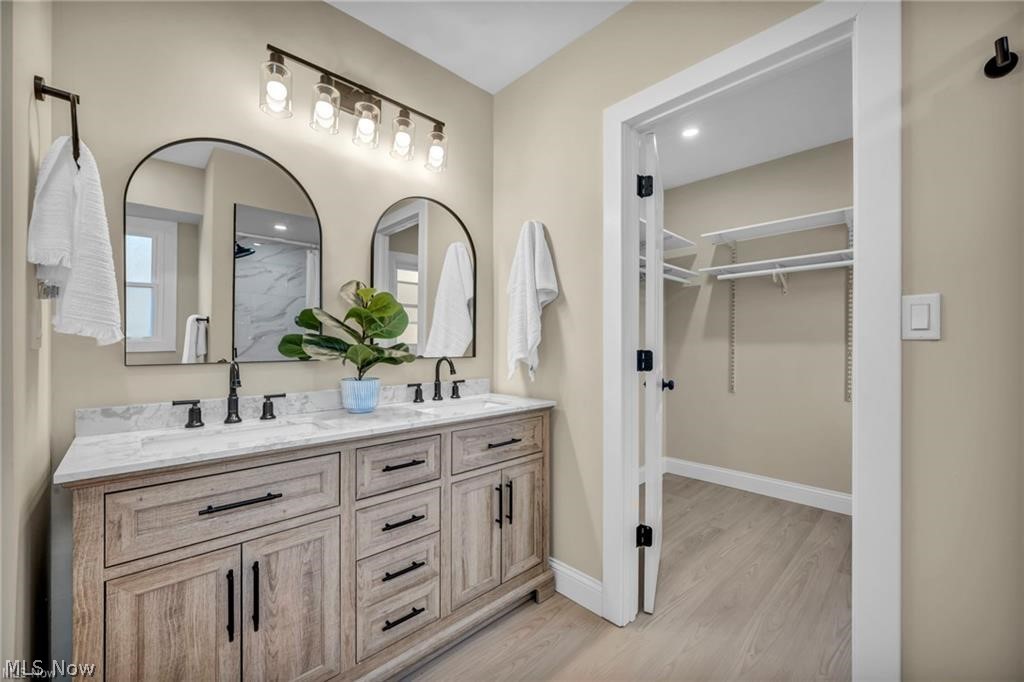 34918 Chestnut Ridge Road North Ridgeville, OH 44039 - Photo 24 of 39 Bathroom featuring double vanity, a walk in closet, light wood-style floors, recessed lighting, and a marble finish shower