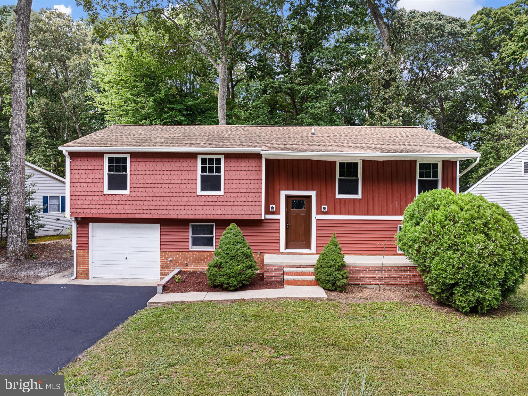 a front view of a house with a garden and plants