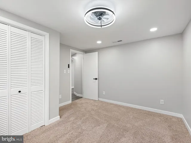 an empty room with window and a ceiling fan