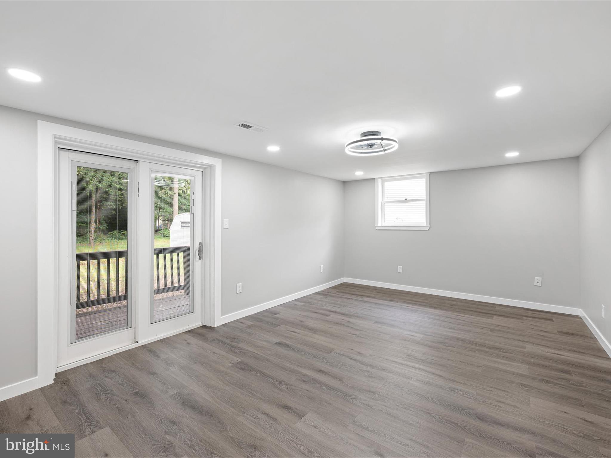 22832 Angola Road East Lewes, DE 19958 - Photo 14 of 43 a view of an empty room with wooden floor and a window