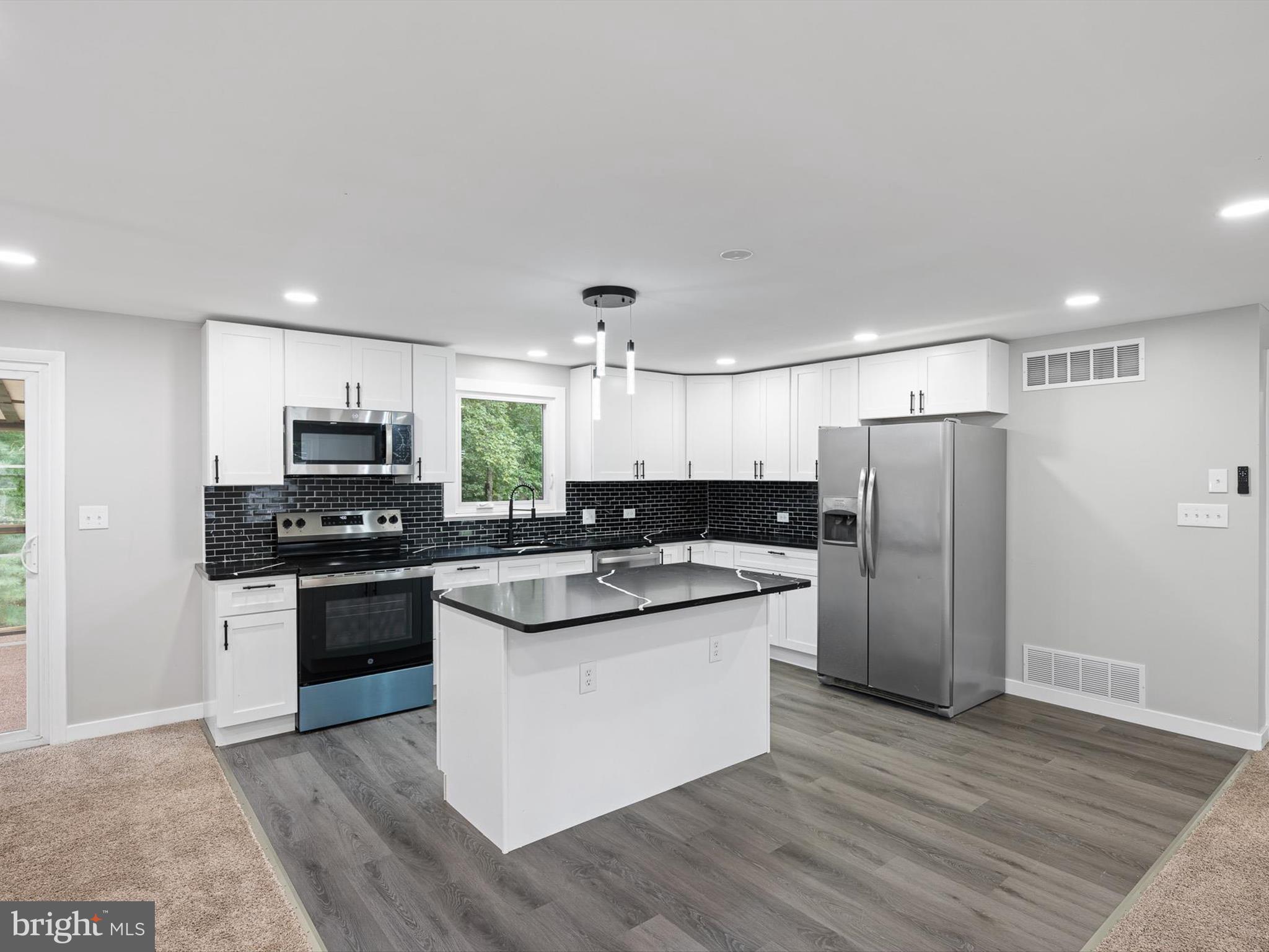 22832 Angola Road East Lewes, DE 19958 - Photo 3 of 43 a kitchen with stainless steel appliances and wooden cabinets
