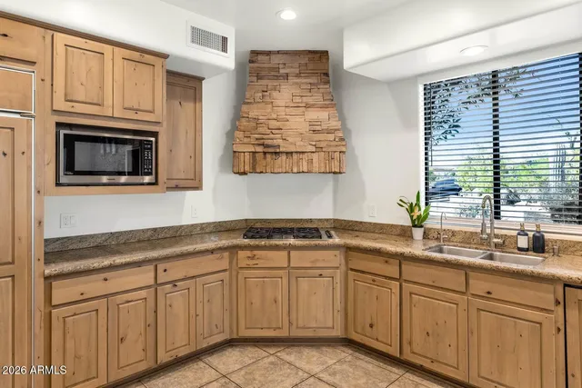 a kitchen with cabinets appliances a sink and a window