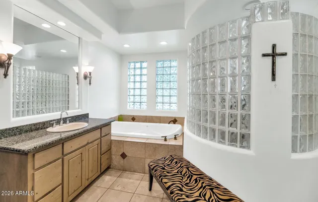 a bathroom with a granite countertop sink and a bathtub