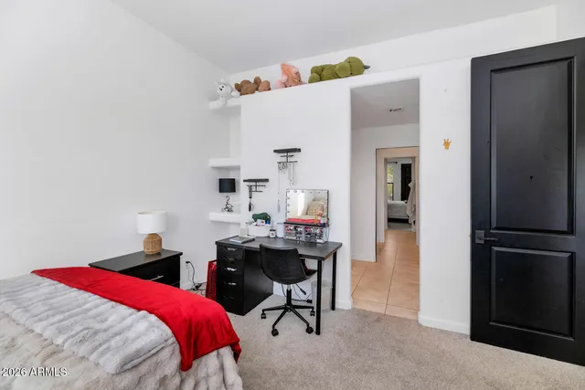 a bedroom with a bed and a desk in it