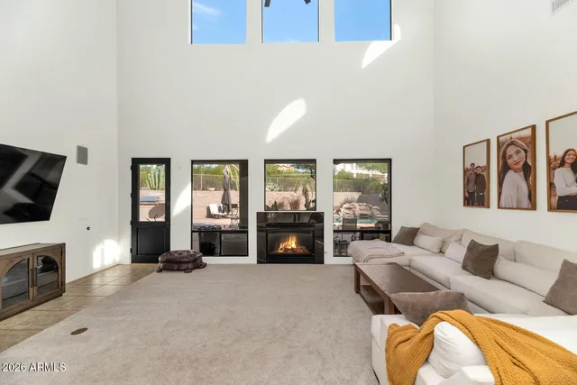 a living room with furniture large window and flat screen tv