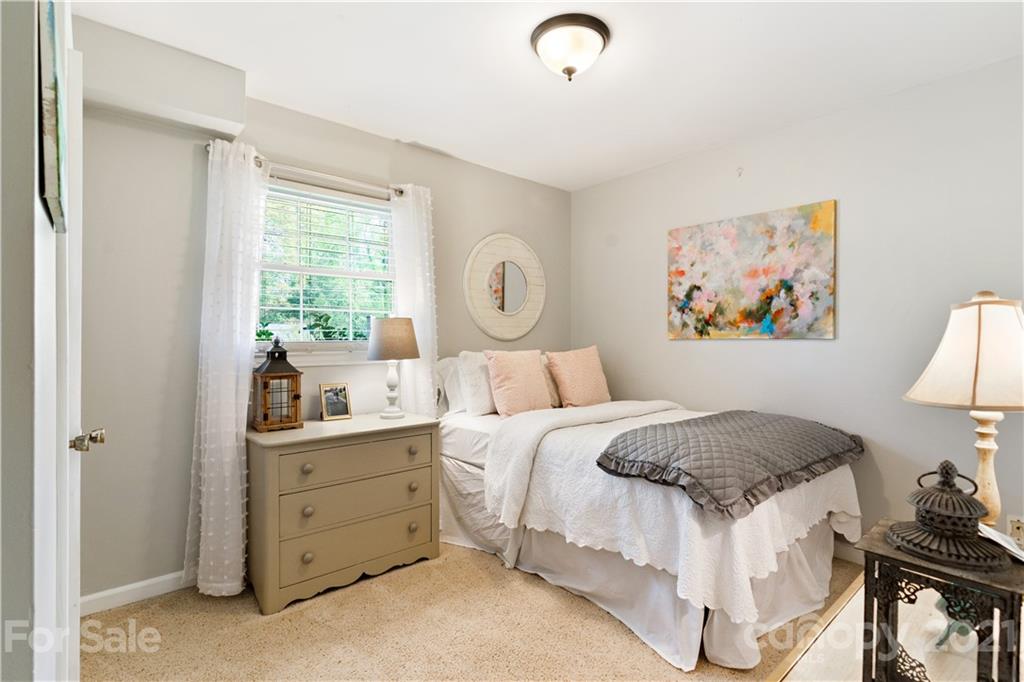 3018 Goneaway Road Charlotte, NC 28210 - Photo 26 of 35 a bedroom with a bed and a lamp on dresser