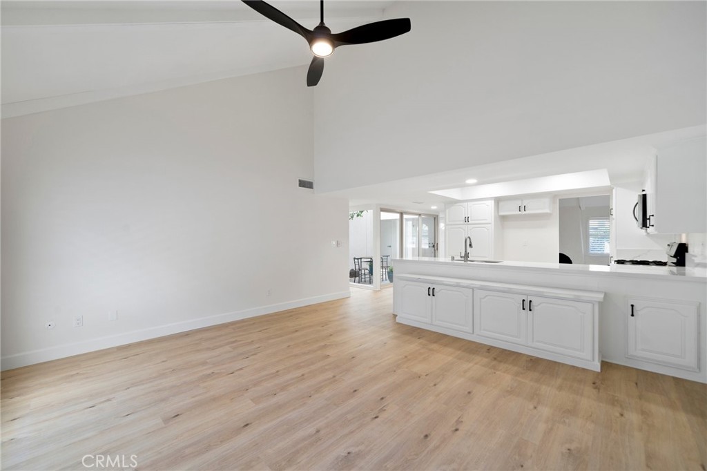 5408 Hanover Drive Cypress, CA 90630 - Photo 12 of 33 a large white room with kitchen island white wooden cabinets and wooden floor