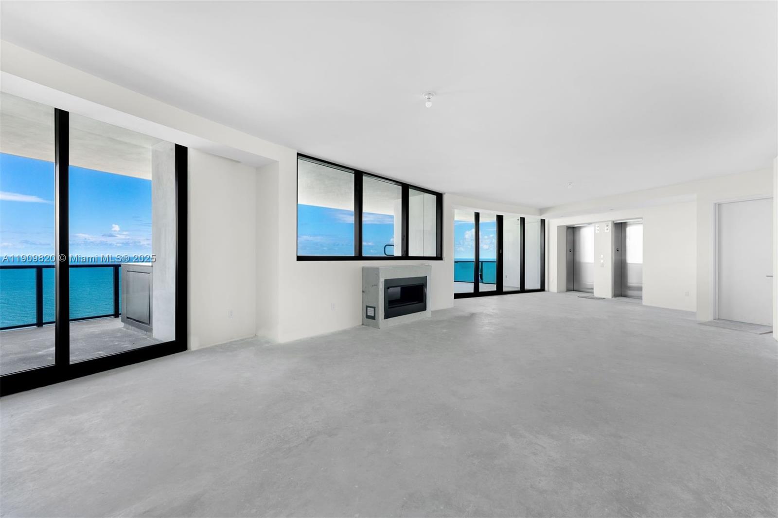 18555 Collins Avenue, Unit 3205 Sunny Isles Beach, FL 33160 - Photo 14 of 50 a view of an empty room with a fireplace and windows