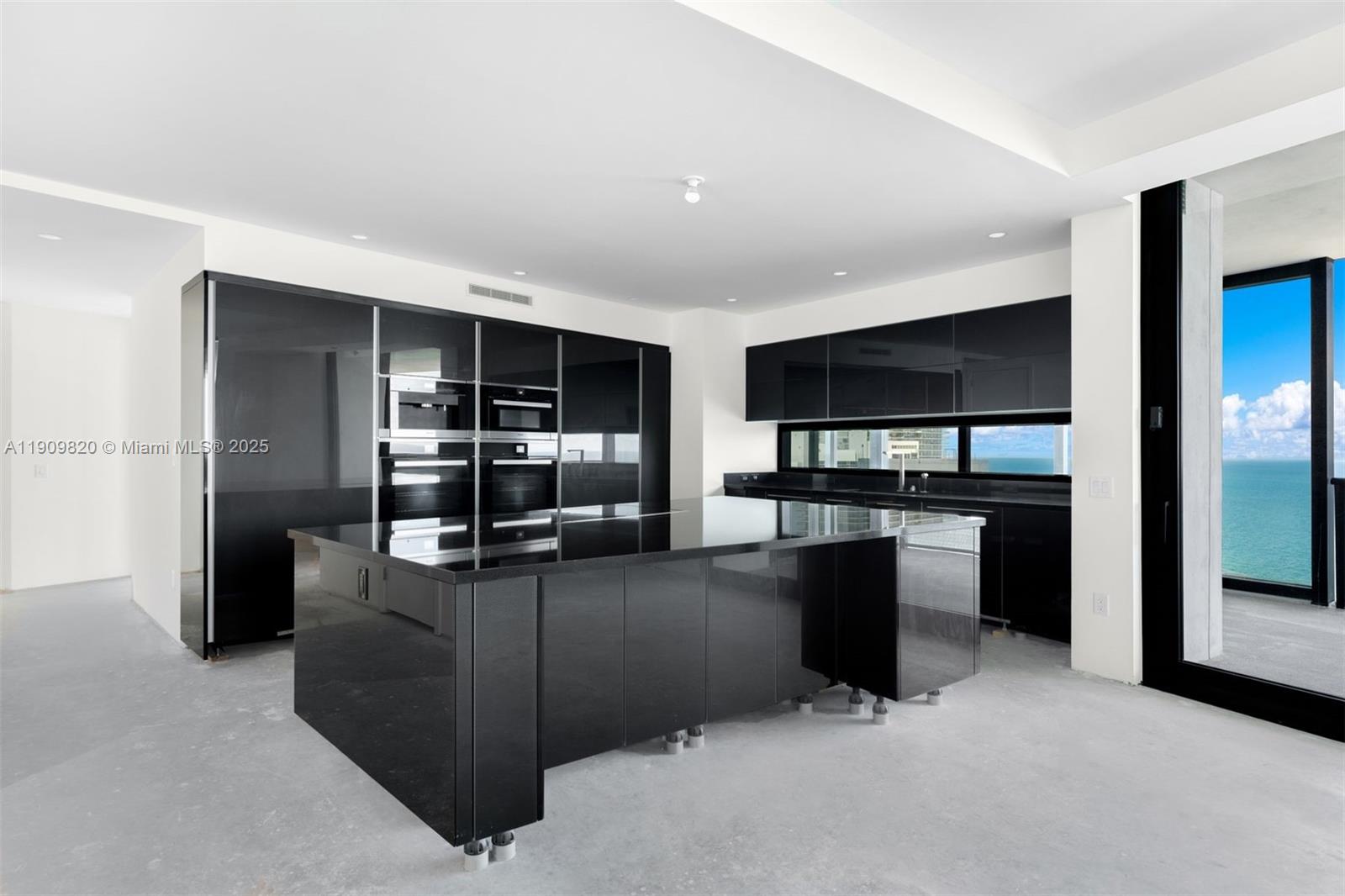 18555 Collins Avenue, Unit 3205 Sunny Isles Beach, FL 33160 - Photo 17 of 50 a kitchen with stainless steel appliances kitchen island granite countertop a refrigerator and a stove