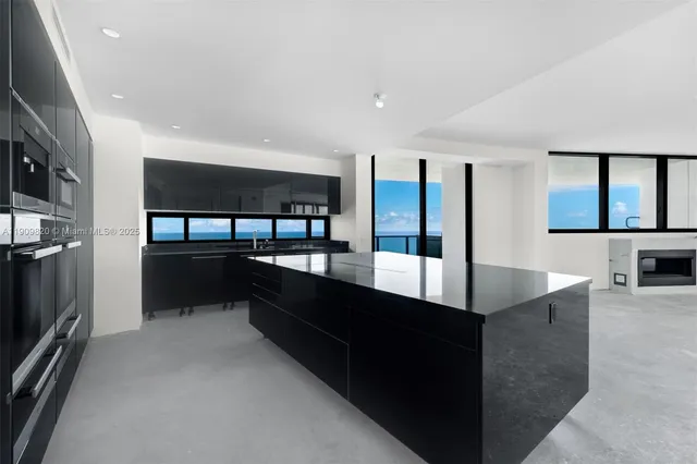 a large kitchen with stainless steel appliances a large counter top