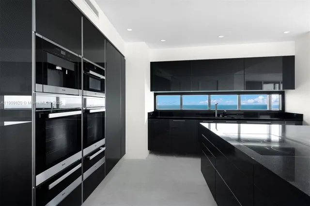 a kitchen with stainless steel appliances kitchen island granite countertop a refrigerator and a stove top oven