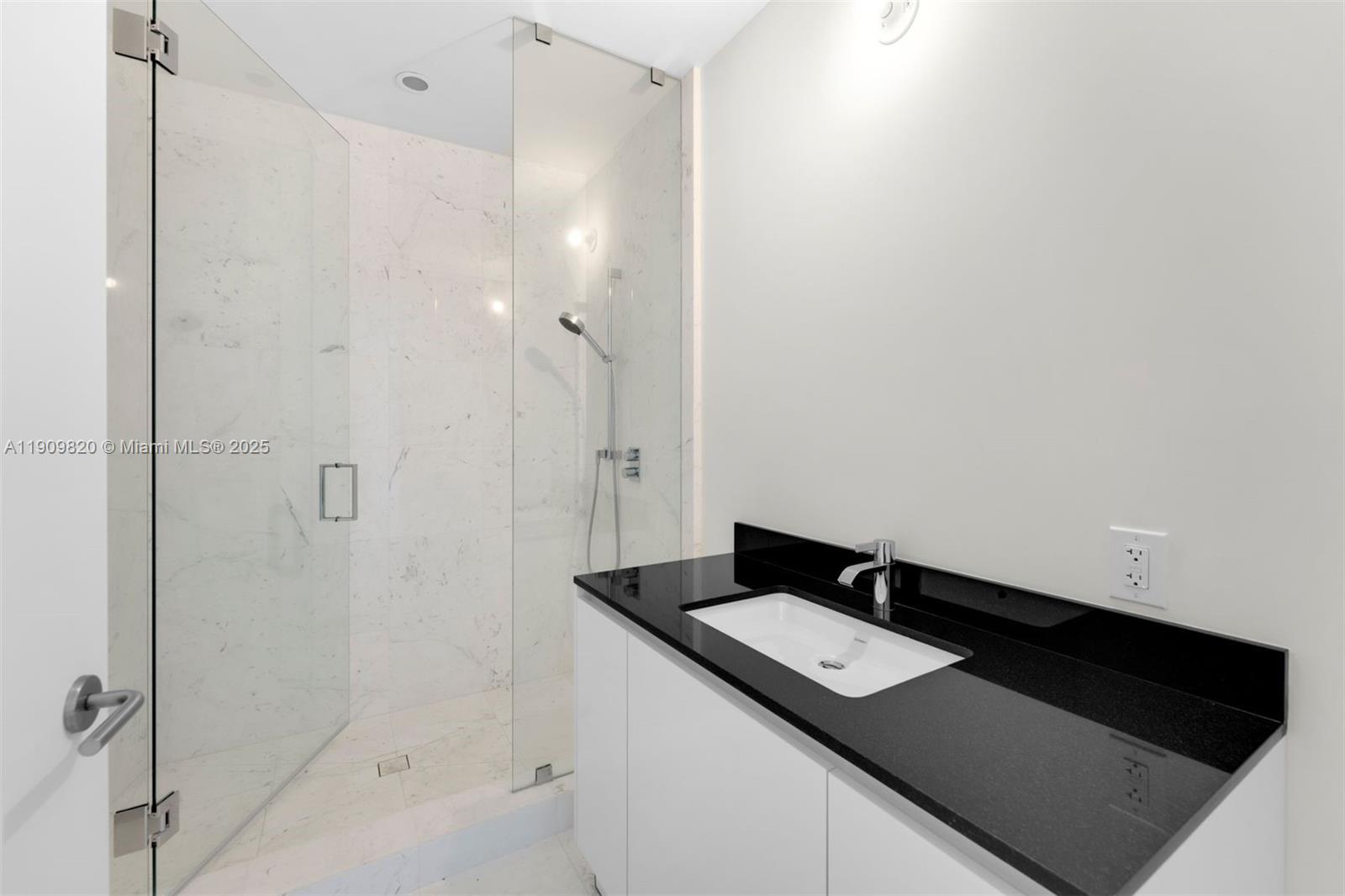 18555 Collins Avenue, Unit 3205 Sunny Isles Beach, FL 33160 - Photo 34 of 50 a bathroom with a granite countertop sink and a mirror