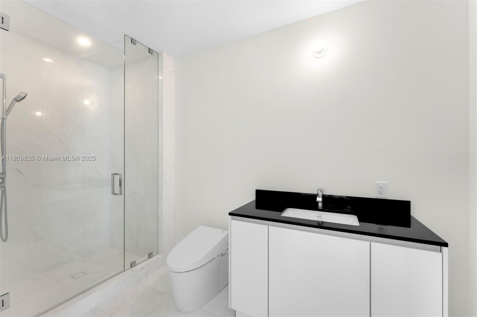 18555 Collins Avenue, Unit 3205 Sunny Isles Beach, FL 33160 - Photo 39 of 50 a bathroom with a toilet a sink and shower