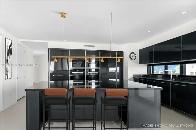 a kitchen with stainless steel appliances kitchen island granite countertop a table and chairs