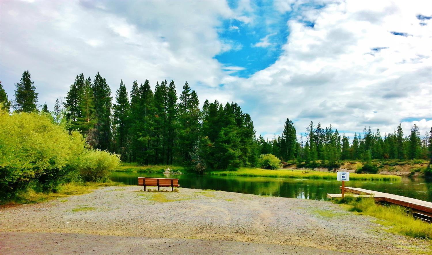 56082 Snow Goose Road Bend, OR 97707 - Photo 4 of 8 a view of a lake with a yard and large trees